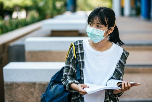 female student wearing mask looking sad
