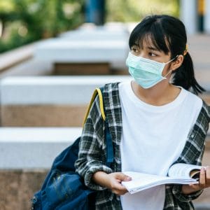 female student wearing mask looking sad