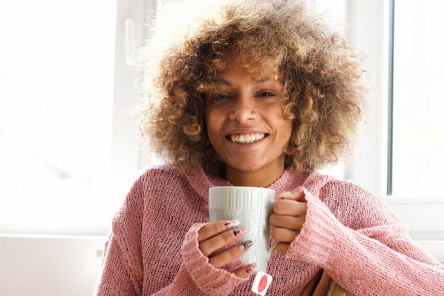 Smiling young woman with a cup of tea